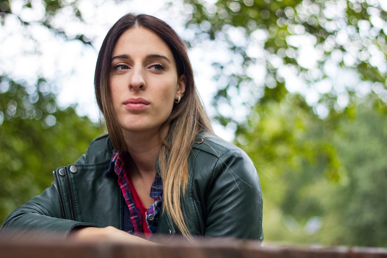 in the park on the bench sits a sad brunette and thinks