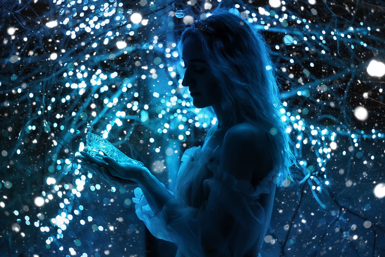 in the evening a blonde stands beside a decorated tree