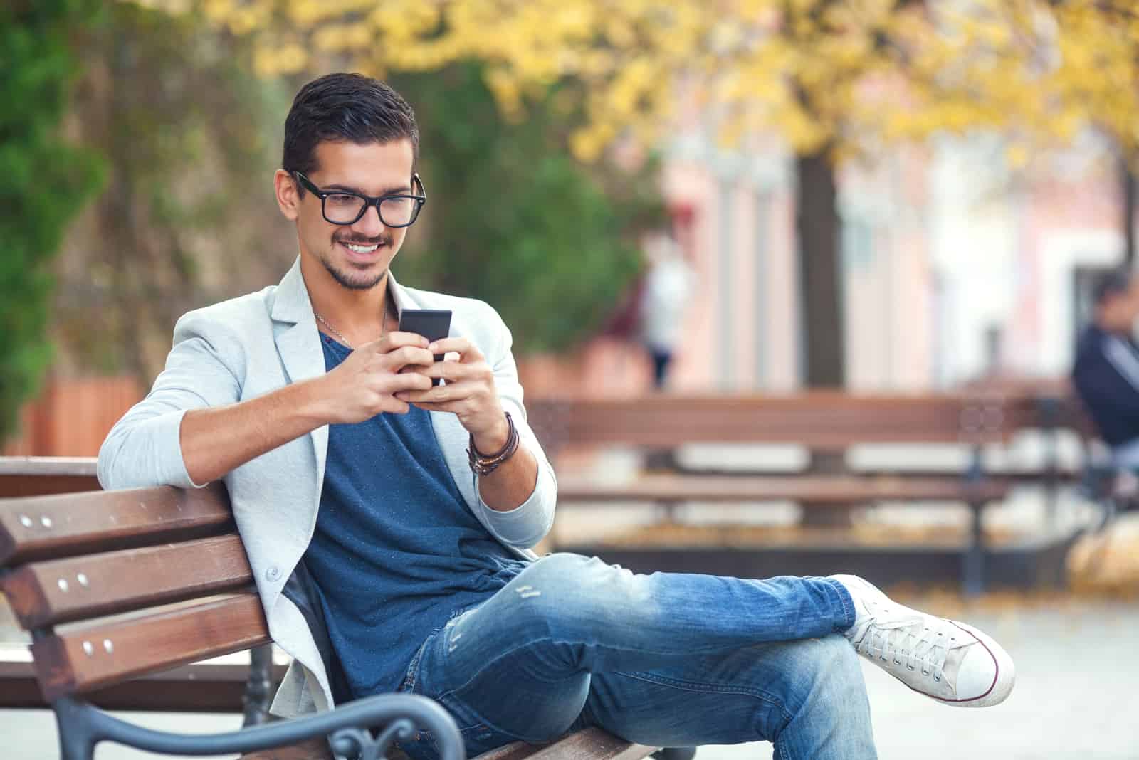 smiling young man texting on the cellphone