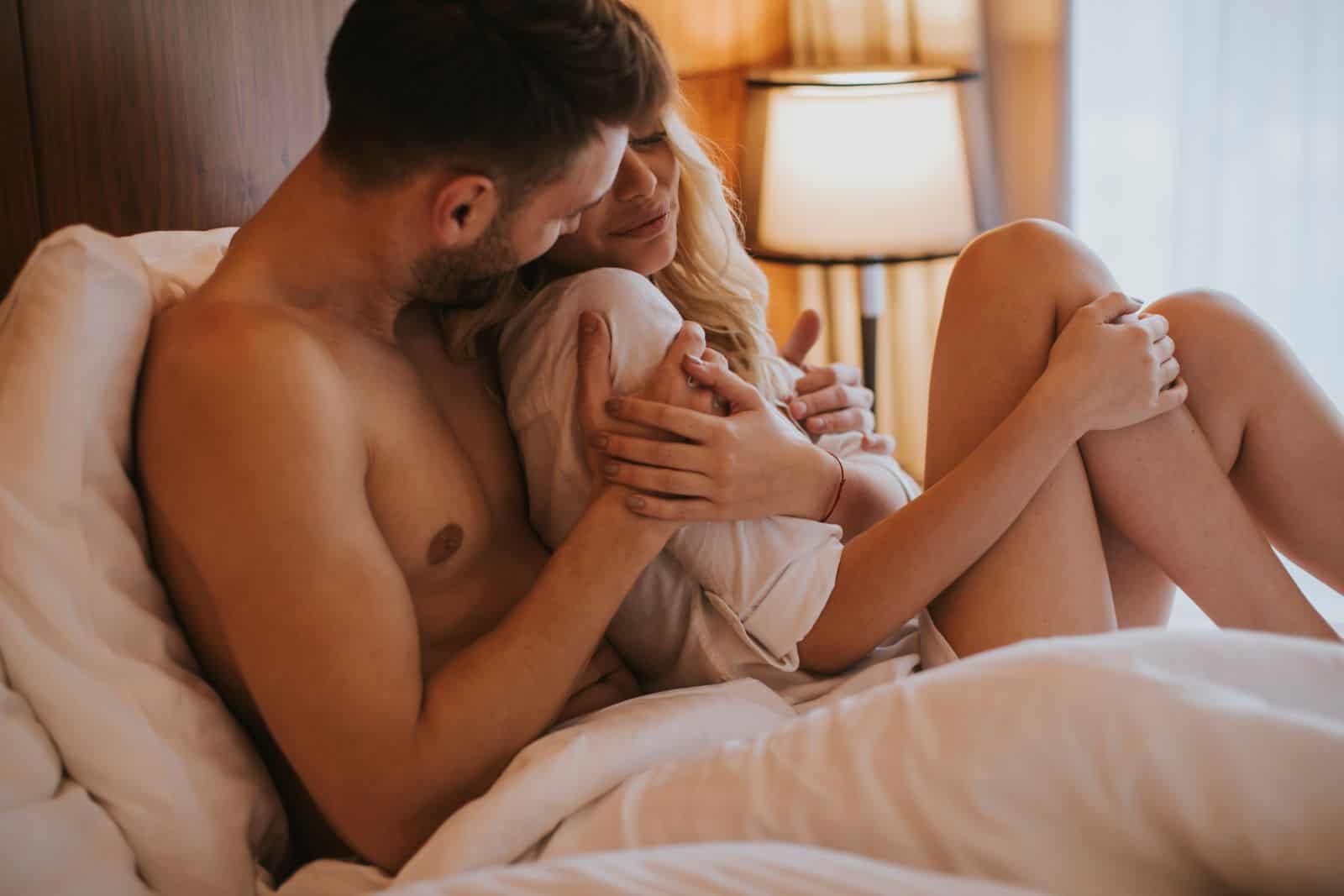 loving couple embracing on bed