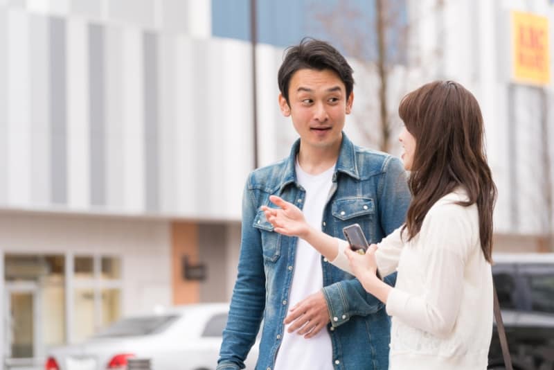 A man approaches a woman on the street, their connection is palpable.