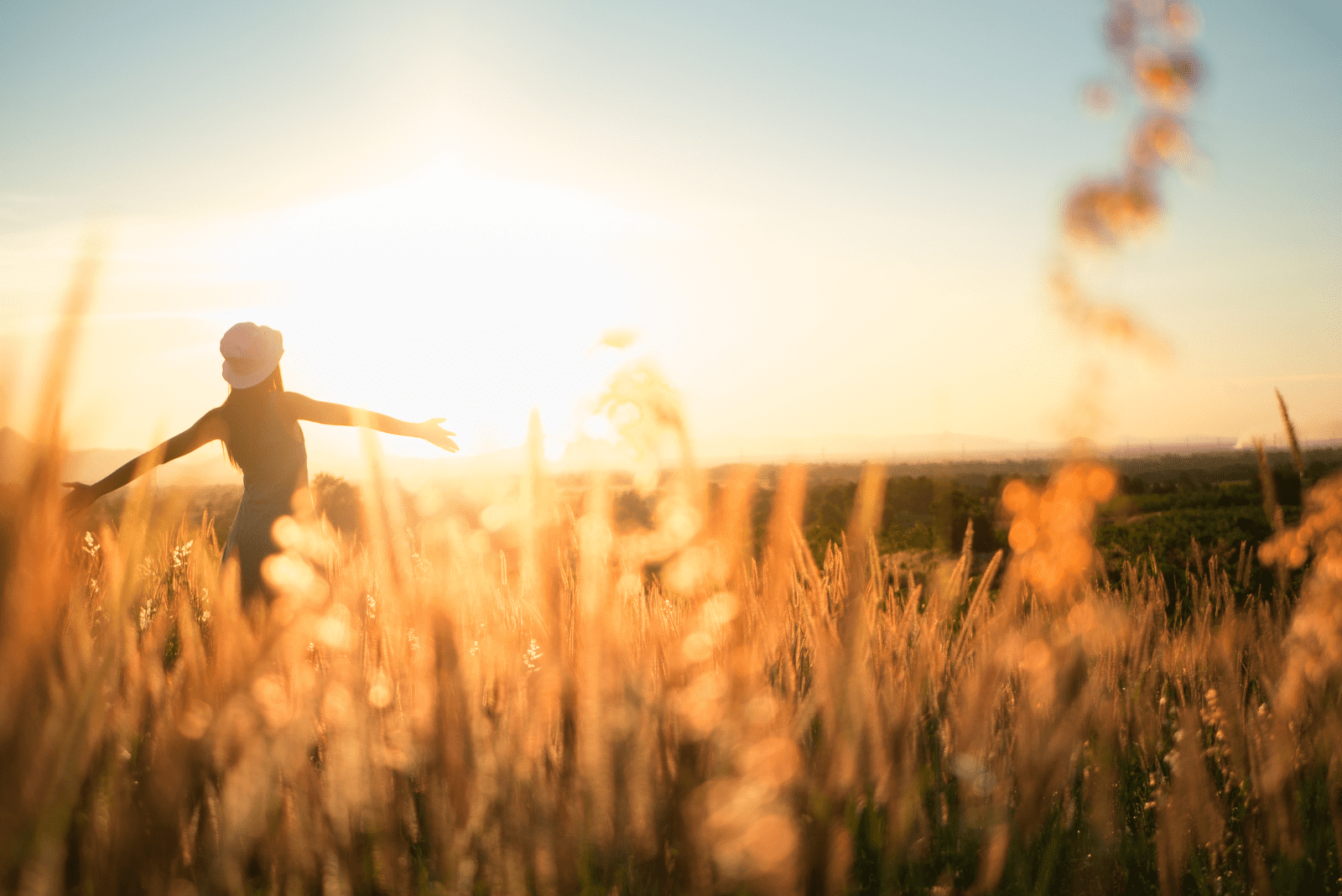 a woman stands in the field with outstretched arms