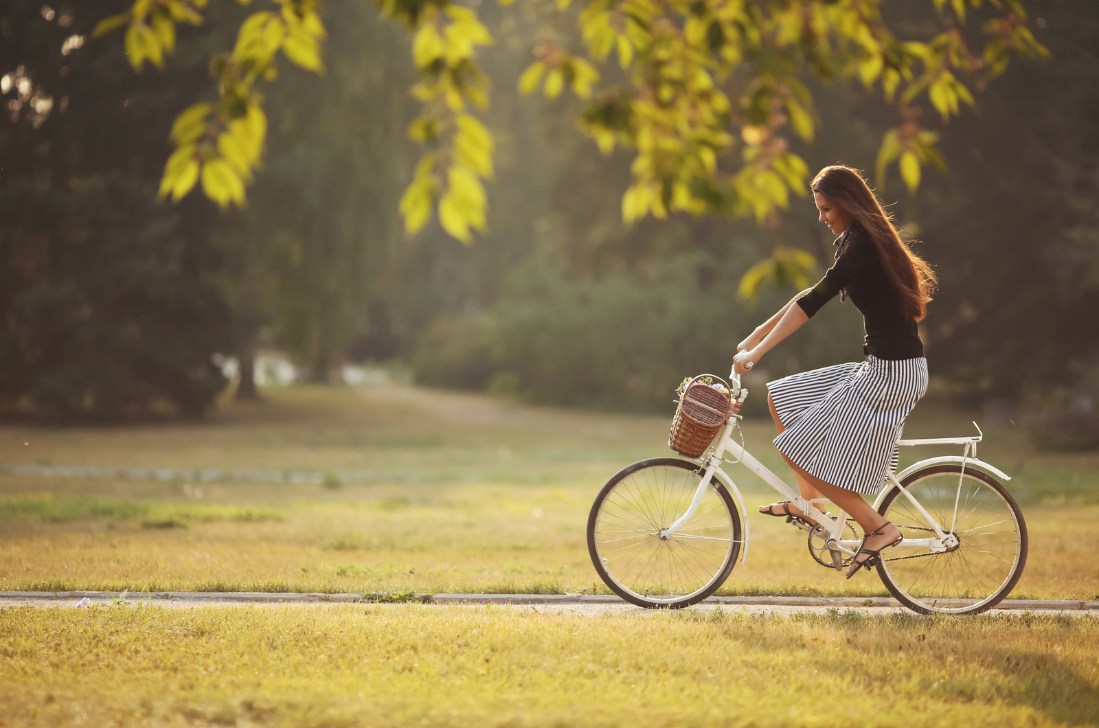 photo of a woman riding a bike in a park