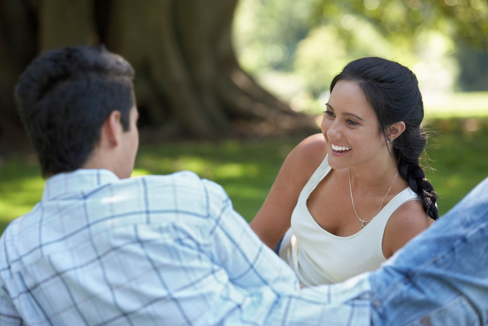 couple lying for picnic in the park talking and laughing