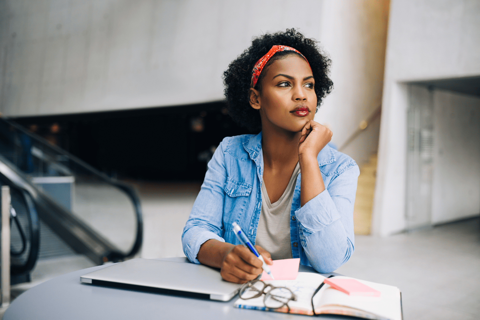 pensive woman sits at the table and writes