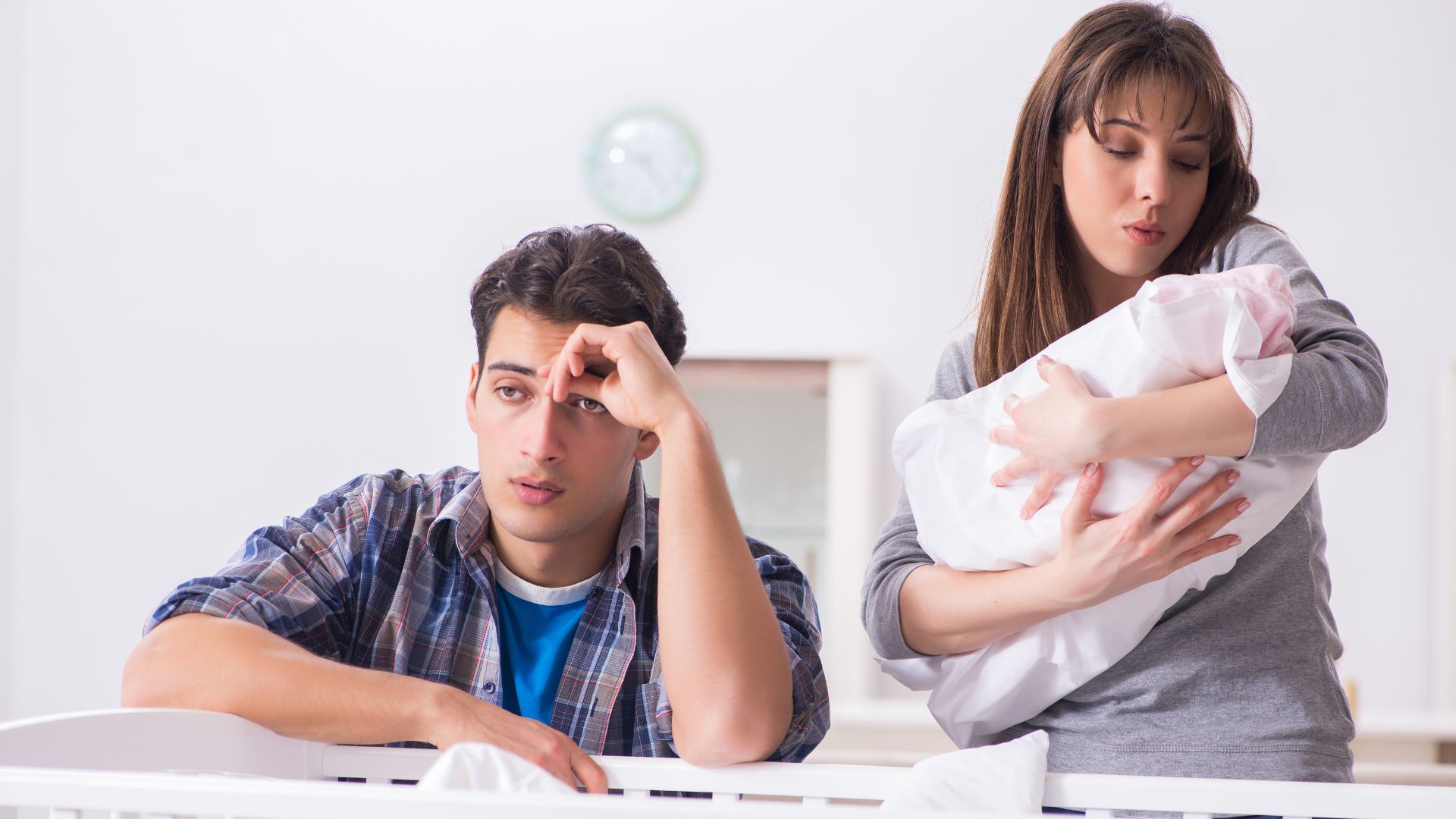 woman holding a baby while dad sitting
