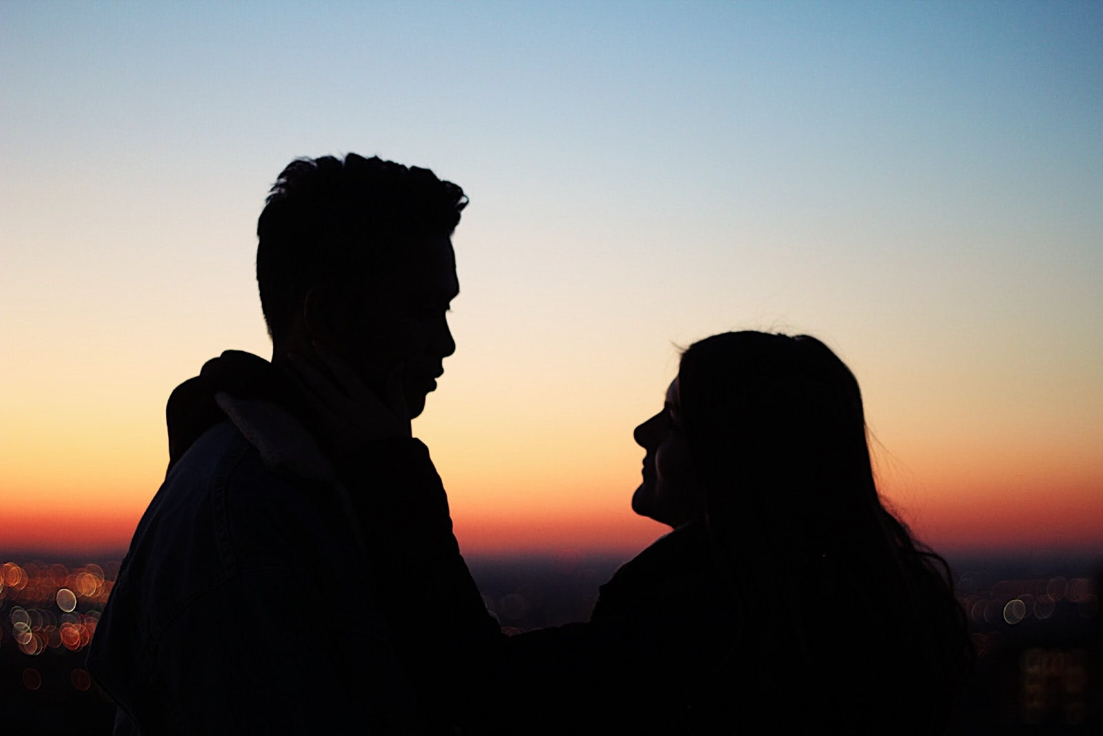 man and woman making eye contact during sunset
