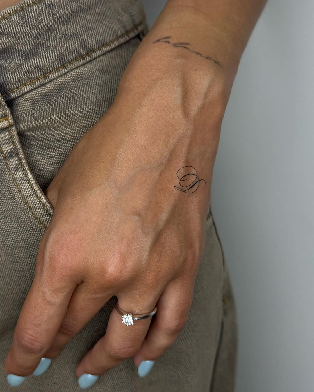 minimalist letter hand tattoo