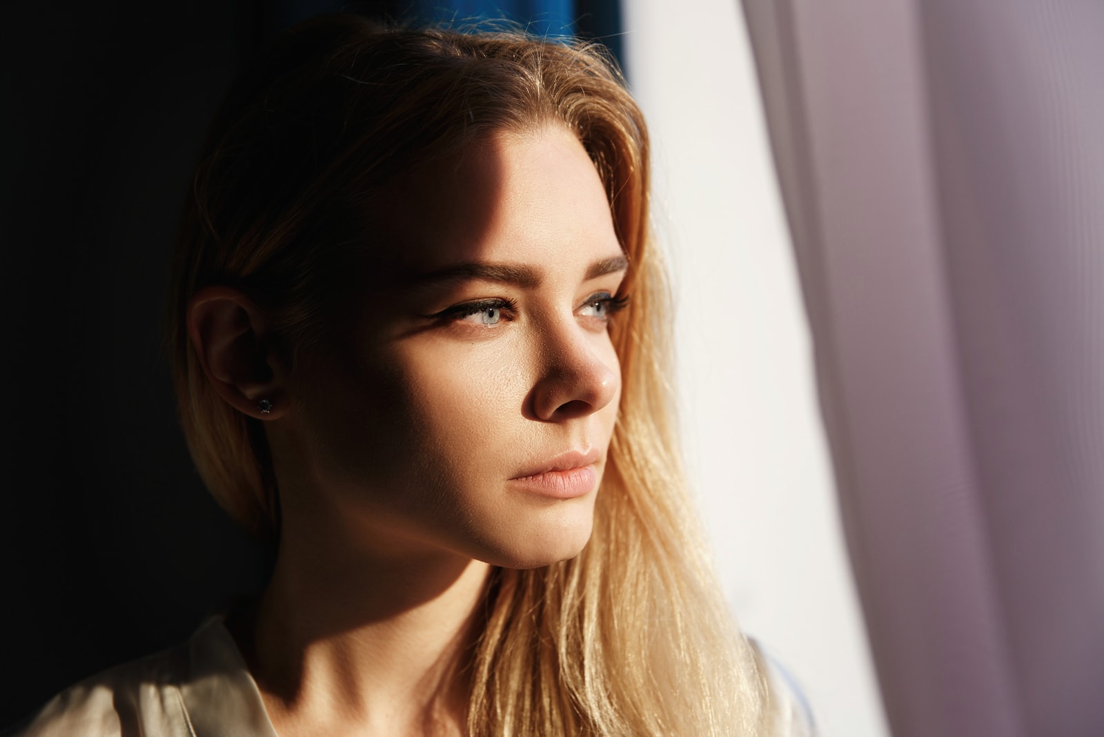 the beautiful blonde looks out the window and thinks