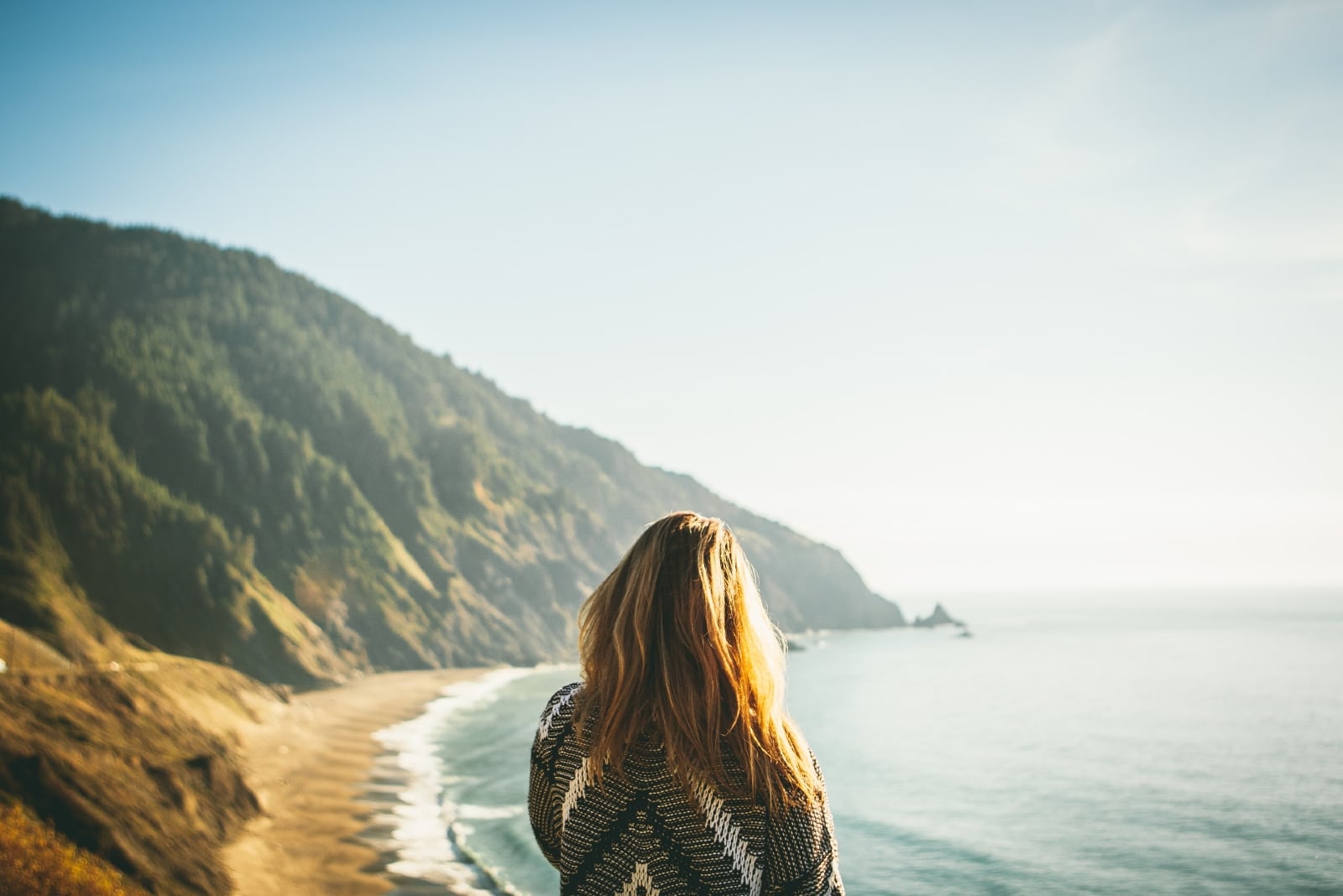 woman in gray sweater gazing at ocean