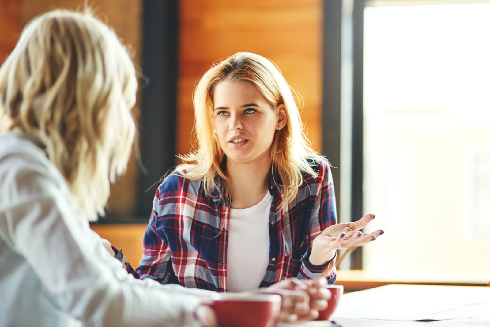 woman chatting with another woman at a table
