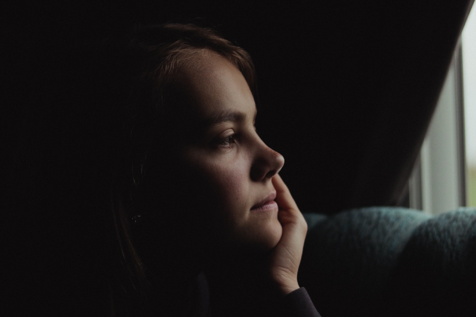 woman touching her face while sitting indoor