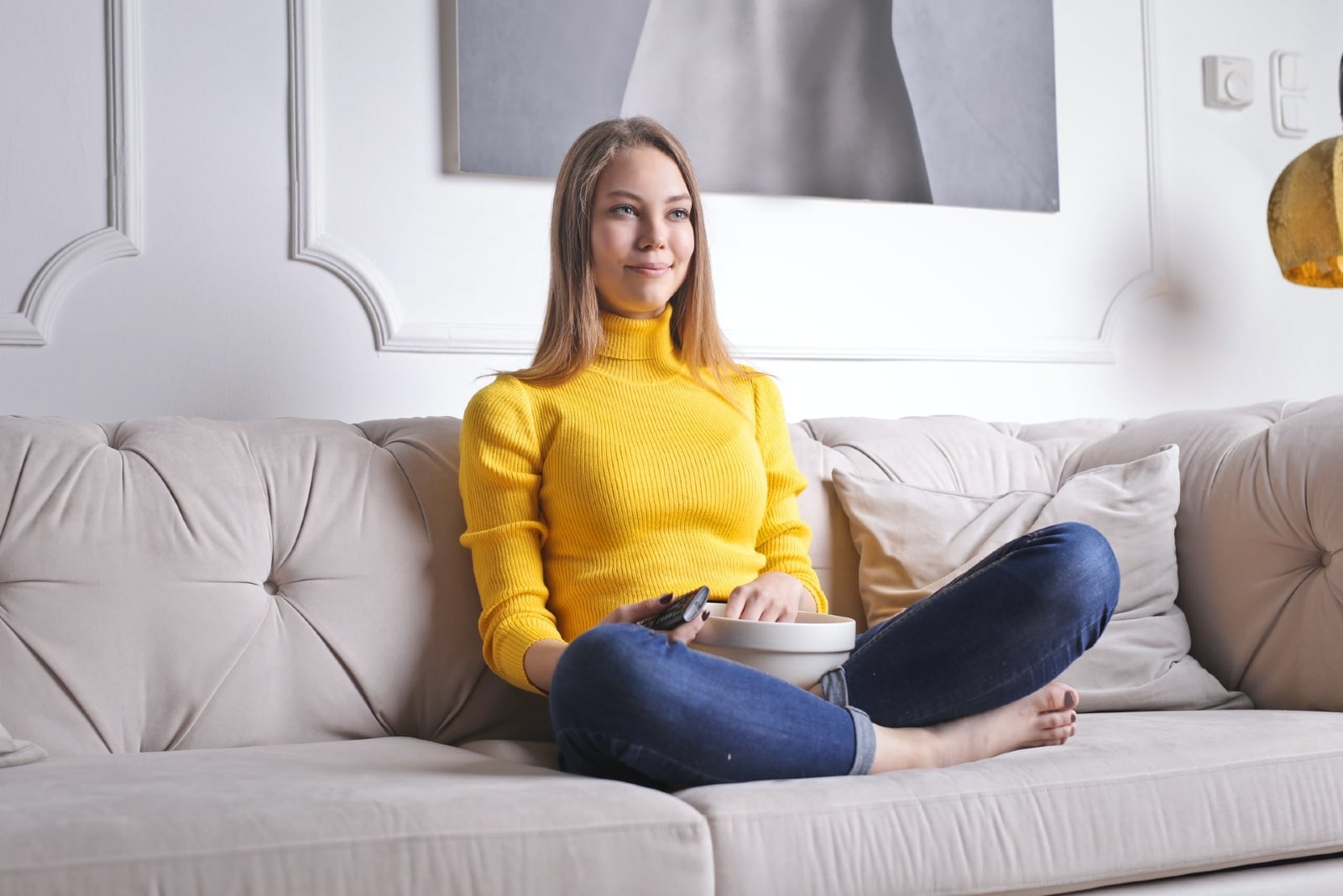woman watching television on a sofa