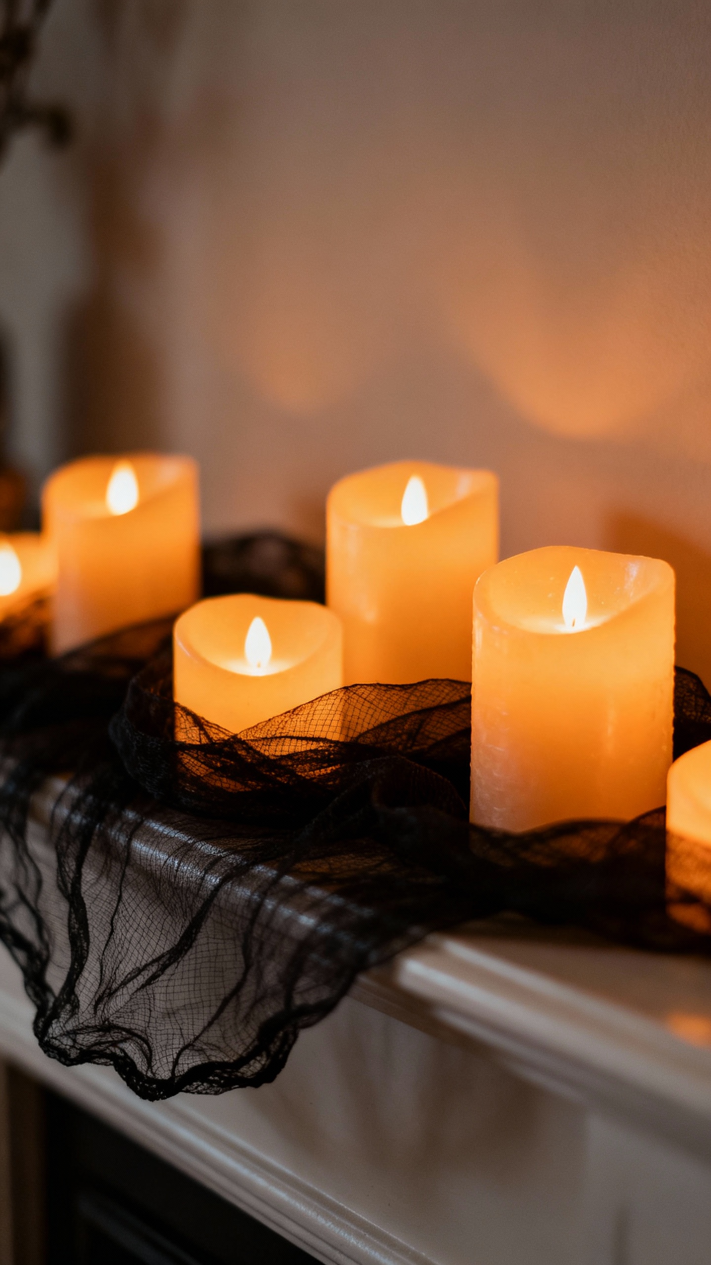 Closeup LED candles clustering on mantel, amber glow, black gauze